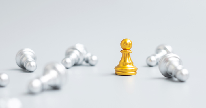 golden chess piece among silver chess pieces that have fallen over